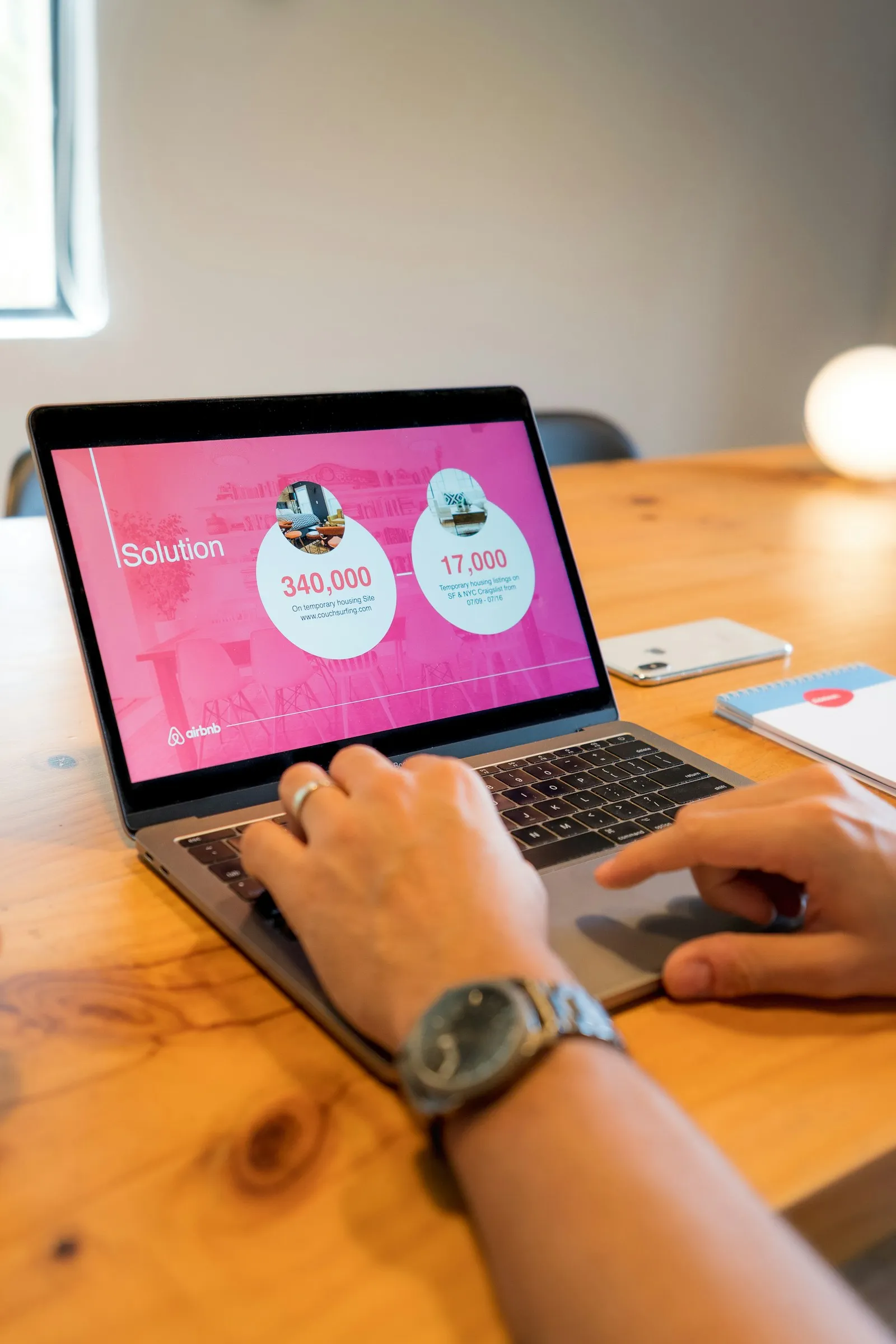 Laptop showing a startup pitch deck on a wooden table