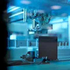 Robotic laboratory arm processing samples in blue light