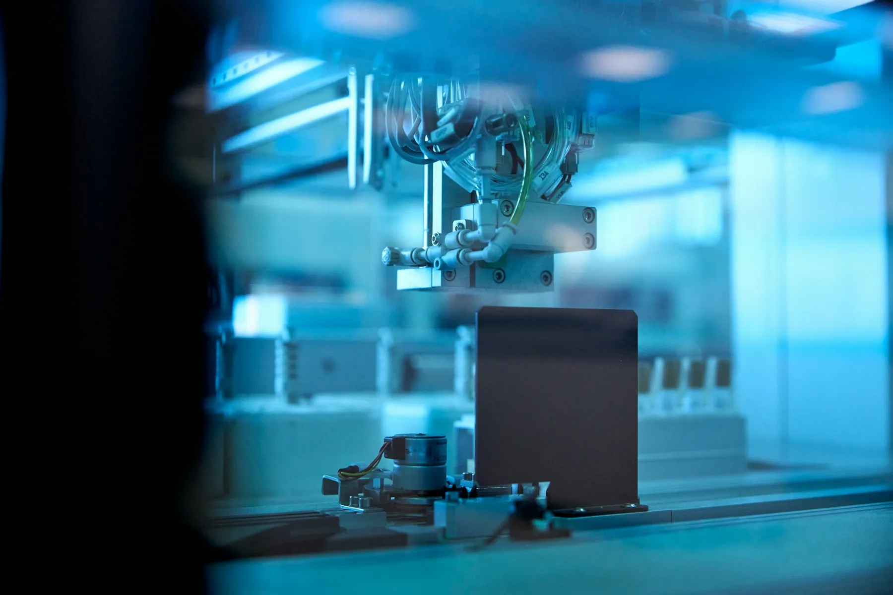 Robotic laboratory arm processing samples in blue light