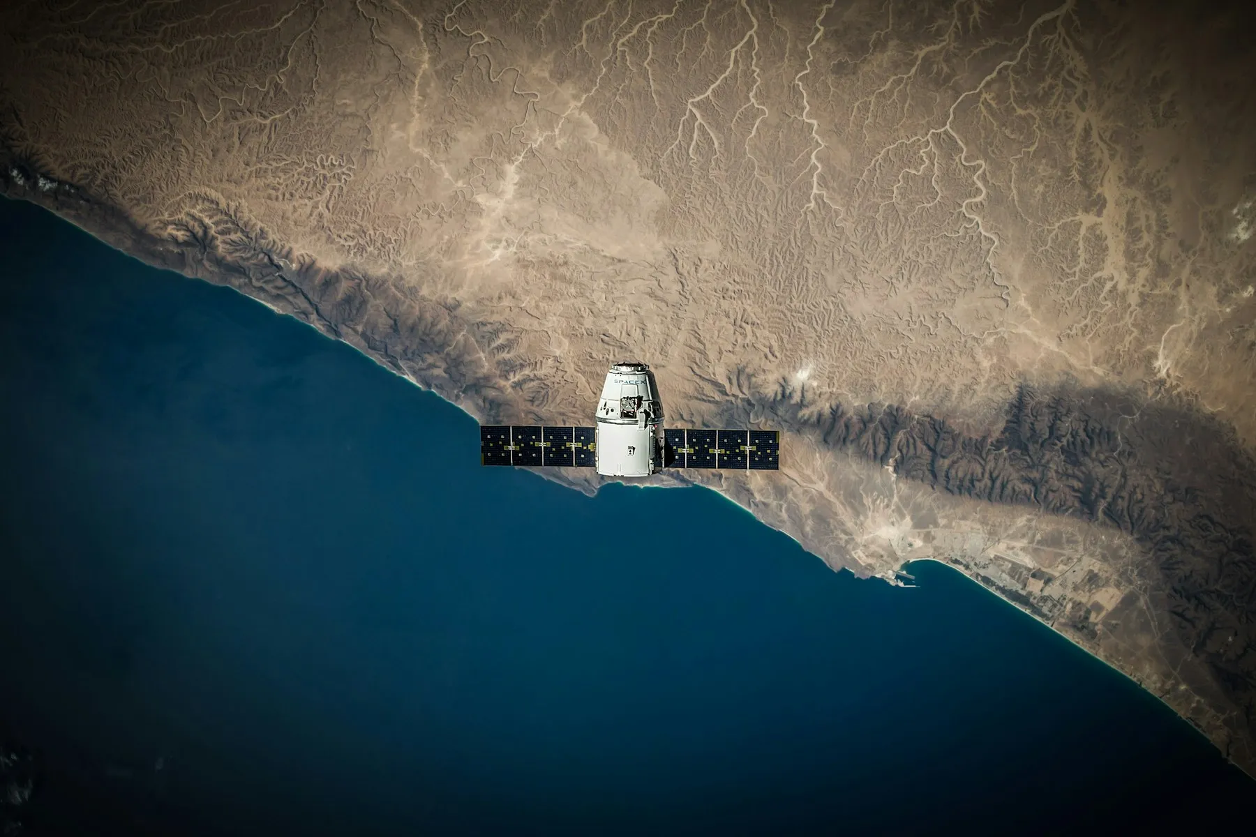 Satellite over a coastline photographed from orbit