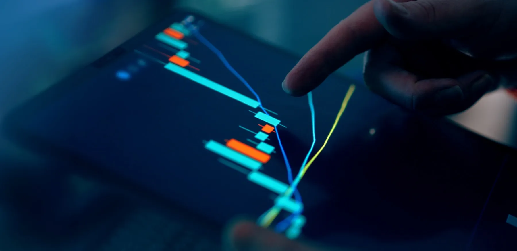 Finger interacting with a candlestick market chart on a tablet